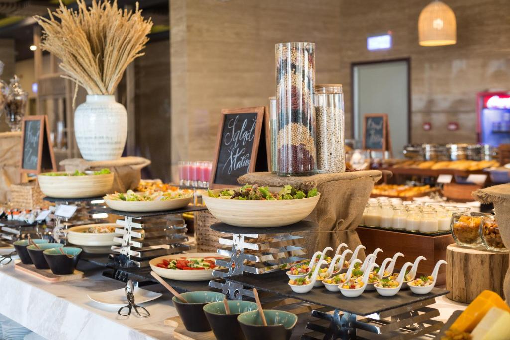 A close view of a breakfast buffet with salads, small dishes and chilled items.