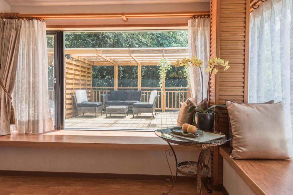 a room with a window with a view of a patio at Crossing The Rainbow Bridge B&amp;B in Chongde