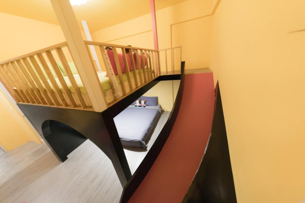 a room with a staircase with a bed in it at Happiness Pediatrics in Xiaoliuqiu