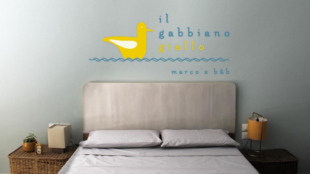 a bedroom with a bed with a yellow duck on the wall at il gabbiano giallo in Fano