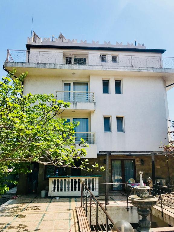 a large white building with a balcony on top of it at Guesthouse in Chernomorets next to Gradina and Sozopol in Chernomorets