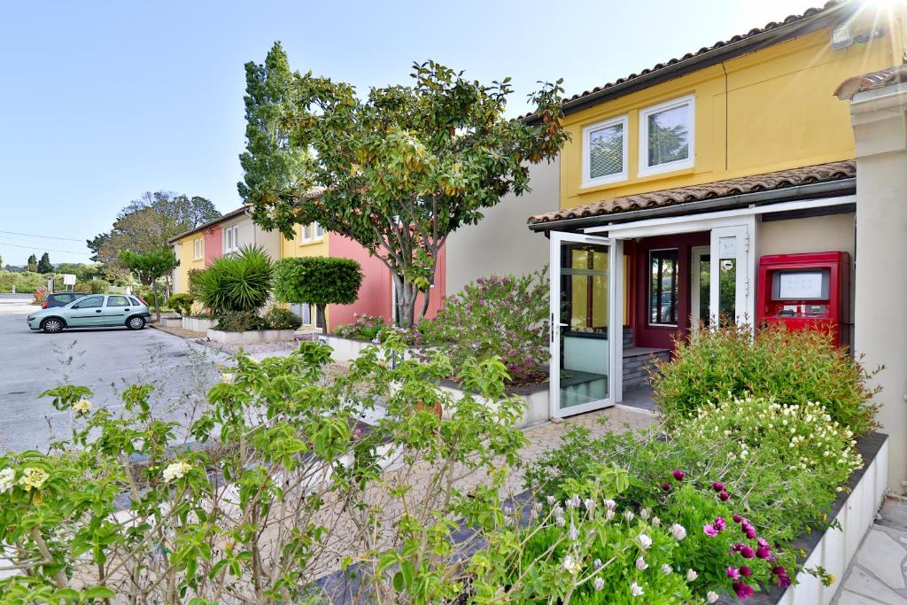 a house with a red door on a street at Hotel Le Coudon in La Farlède