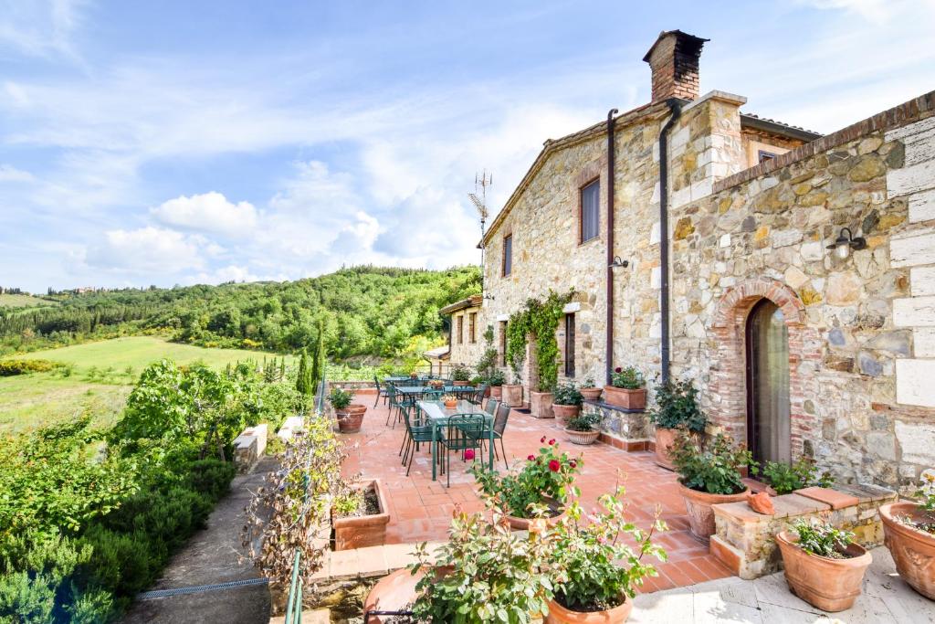 a stone house with a patio with tables and chairs at Podere Perelli in Castiglione dʼOrcia