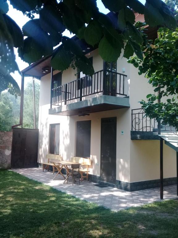 a house with a balcony and a table and chairs at Arthur Rest House in Dilijan