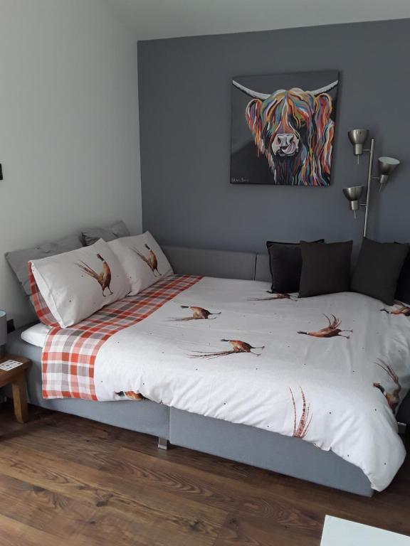 a bedroom with two beds and a painting of a tiger at Byers Guest house in Banavie