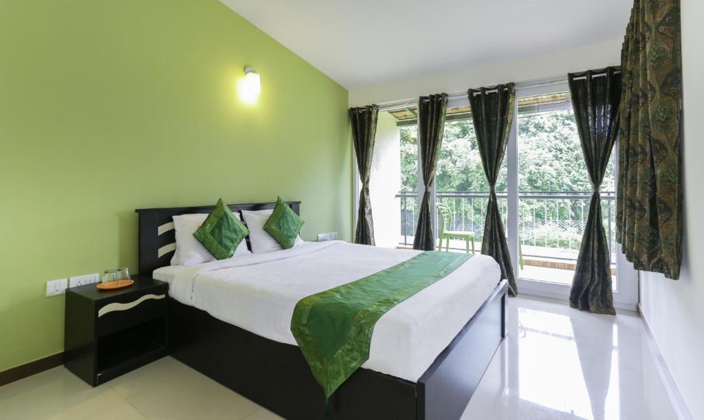 - une chambre avec un grand lit et une fenêtre dans l'établissement Treebo Trend Laa Gardenia Resort Yelagiri, à Yelagiri