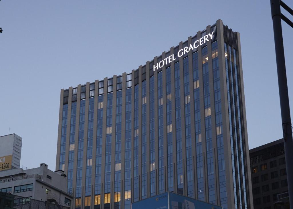 Hotel Gracery Seoul في سول: مبنى طويل عليه علامة الفندق للسرطان