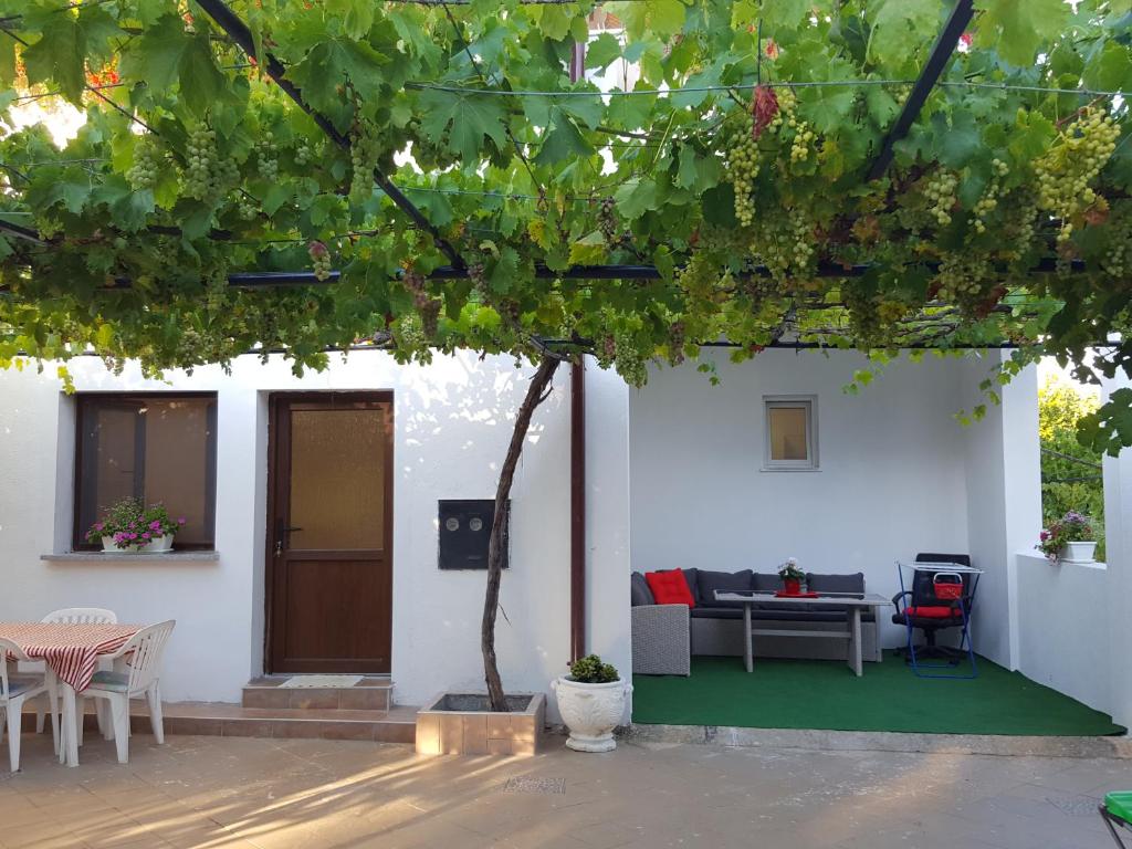 a patio with a table and chairs and a tree at Studio Apartman D&D in Banjole