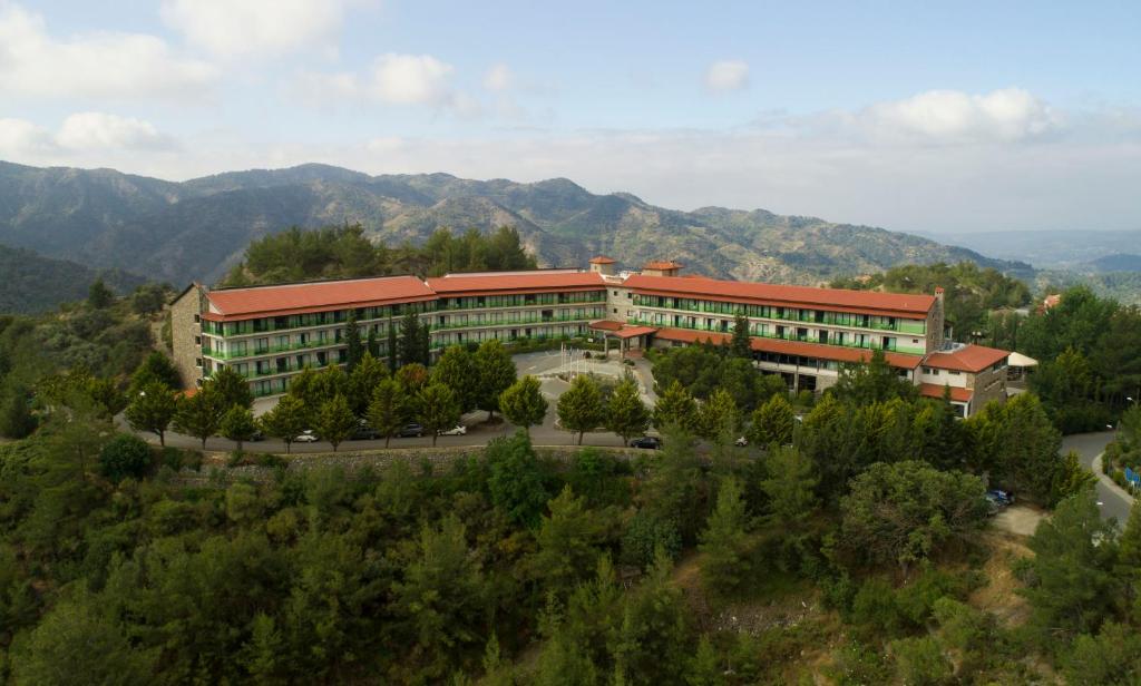 um edifício de escritórios com montanhas ao fundo em Rodon Hotel and Resort em Agros