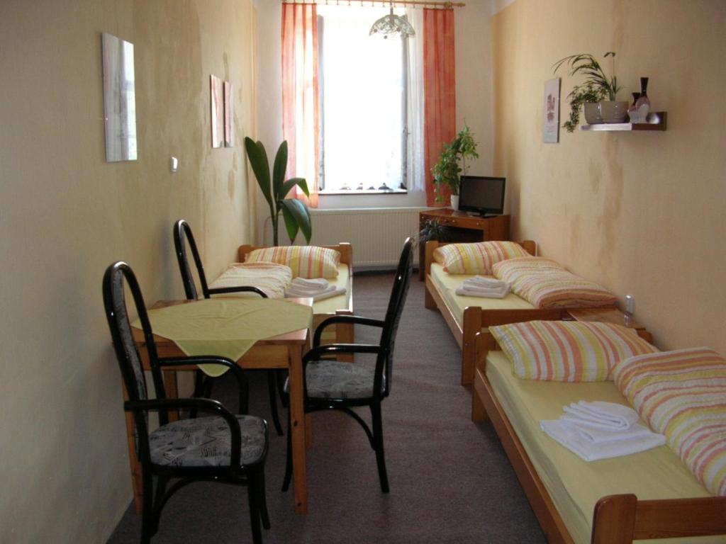 um quarto com camas e uma mesa e cadeiras em Privat U Spazalů em Telč