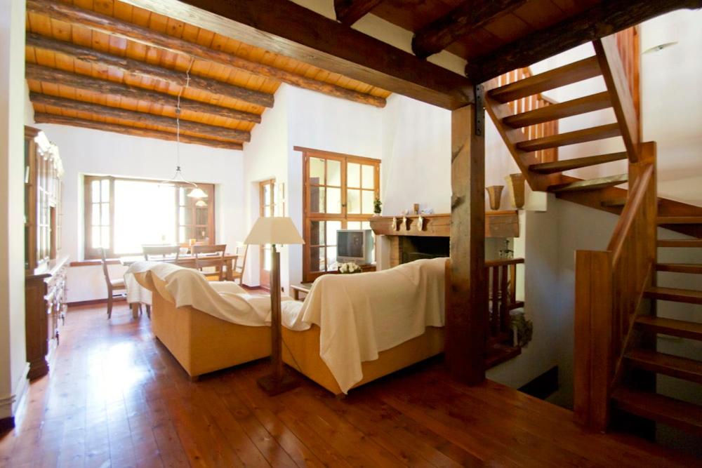 uma sala de estar com um grupo de camas num quarto em H4, Bordes d'Arinsal, Triplex Rustico con chimenea, Arinsal, Zona vallnord em Mas de Ribafeta
