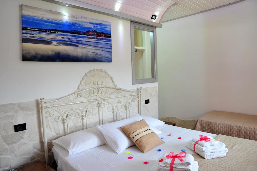a bedroom with a white bed with two towels on it at Tenuta Paifer in Otranto
