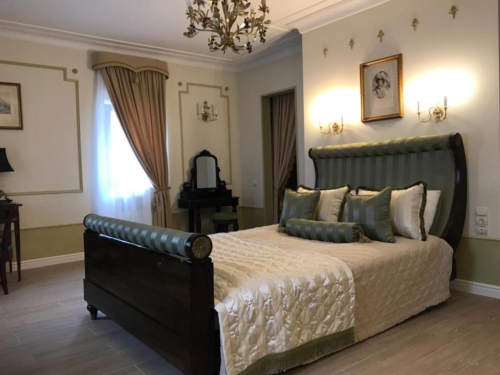 a bedroom with a large bed and a chandelier at La Ferme de Reve in Donoshovo