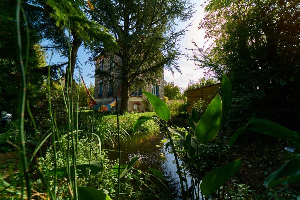 a garden with a pond in front of a house at Gite bord de Marne Paris in Bry-sur-Marne