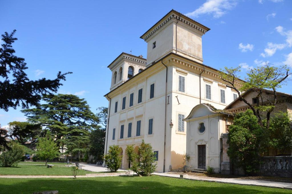 a large white building with a tower on top at Ostello Villa Redenta in Spoleto