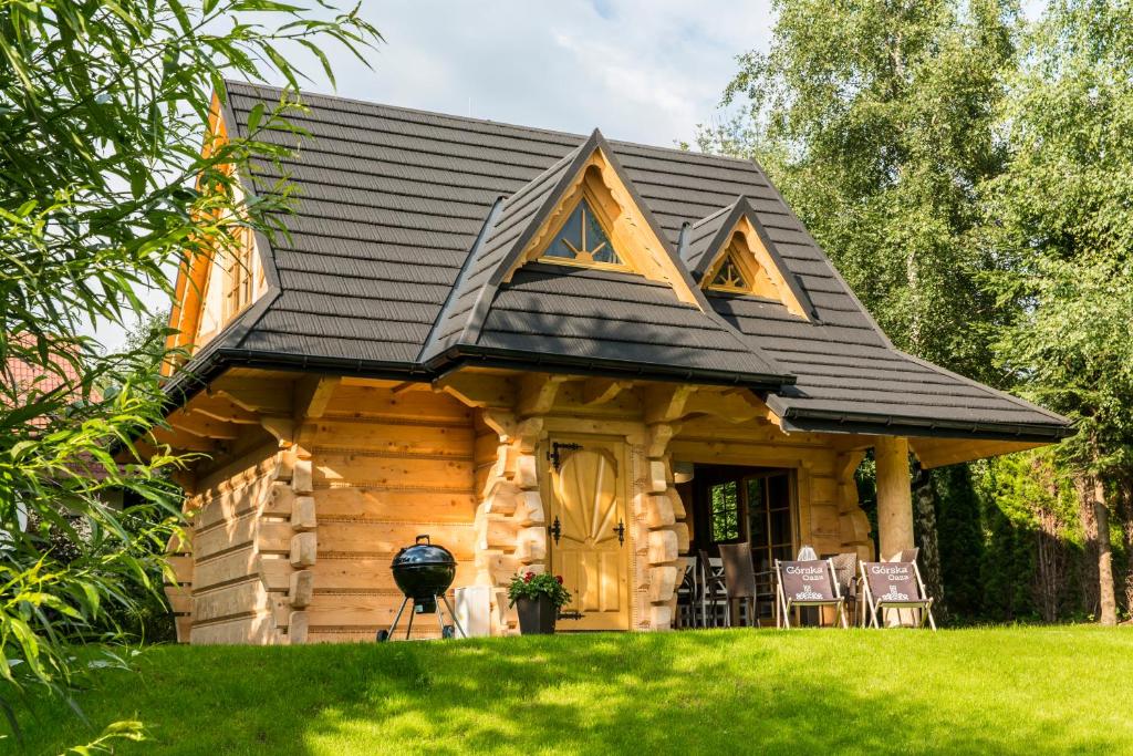 a log cabin with a black roof at udanypobyt Domek Górska Oaza in Kościelisko