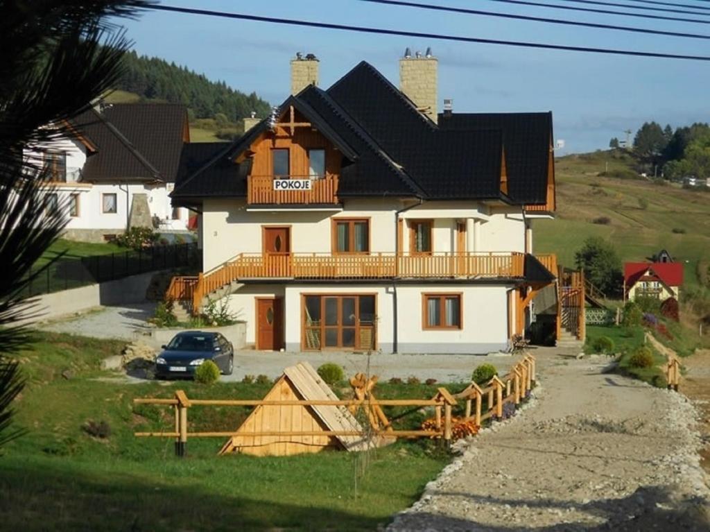 a house with a fence in front of it at Willa Jaroszówka in Kluszkowce