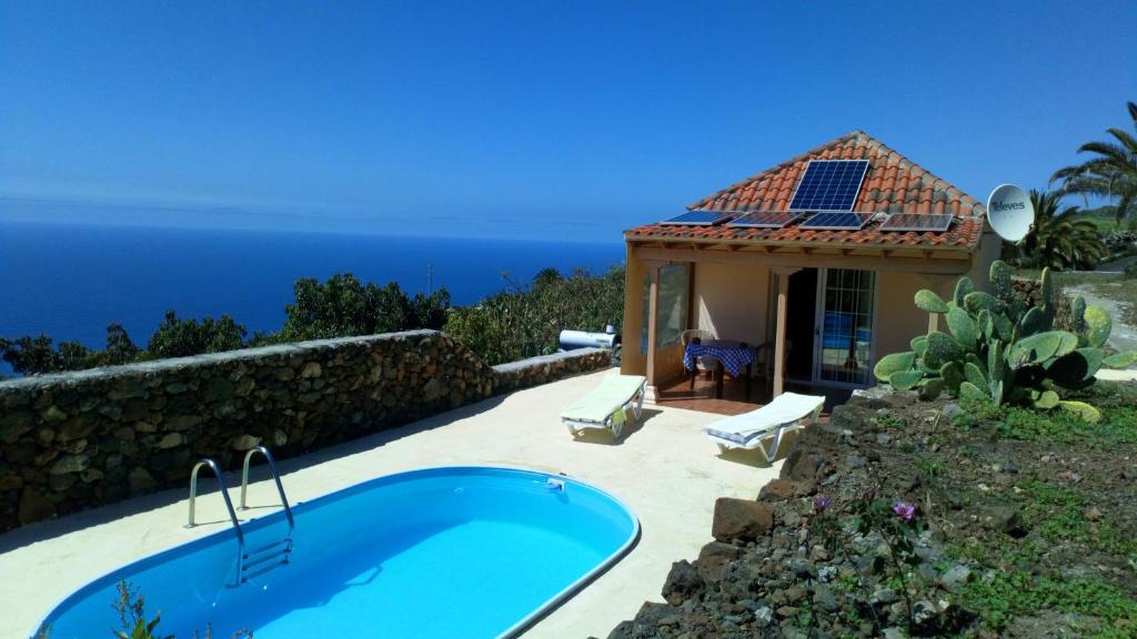 a house with a swimming pool next to the ocean at Finca Alexa in Arecida