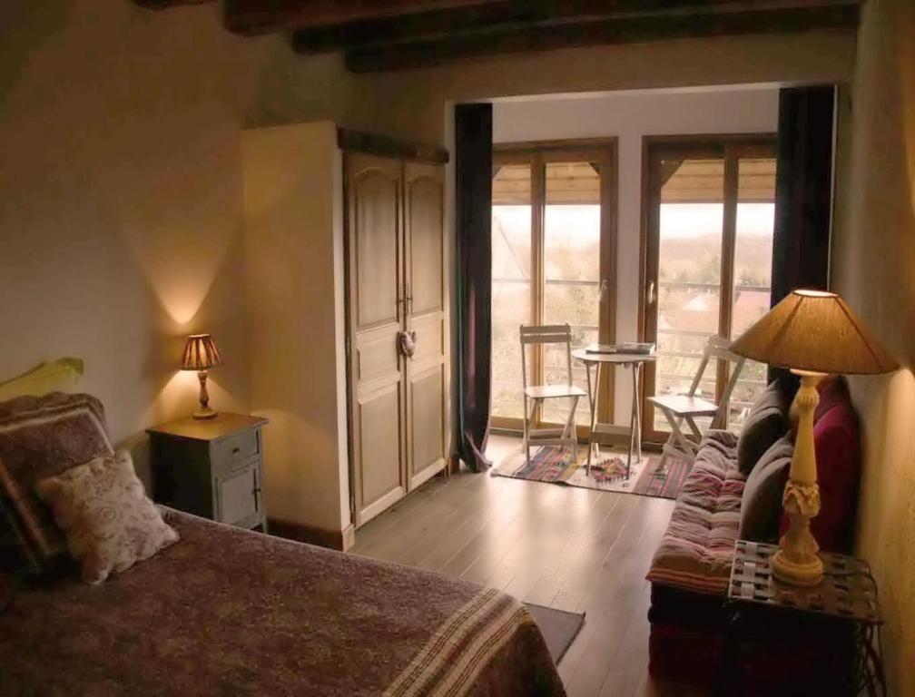 1 dormitorio con 1 cama y 1 habitación con balcón en La Grange aux Loirs B&B, en Courtioux