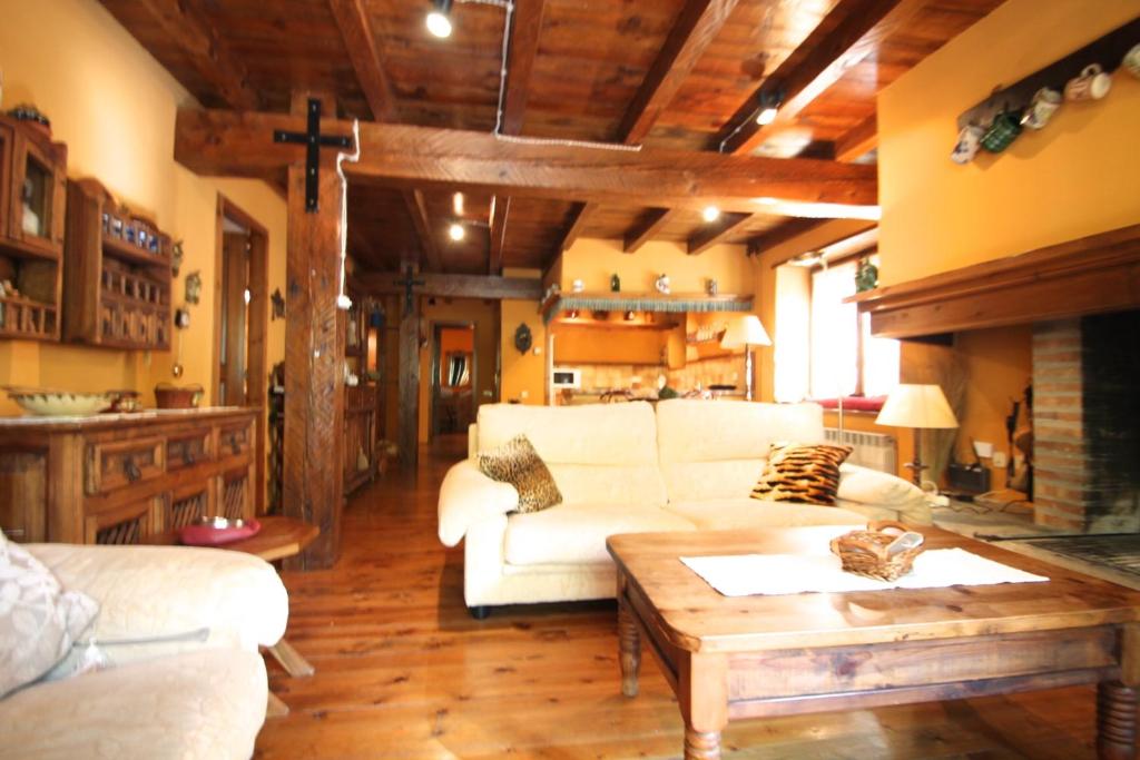 a living room with a white couch and a table at Pleta Aldosa, Casa rustica con chimenea y jardin, Zona Vallnord in La Massana