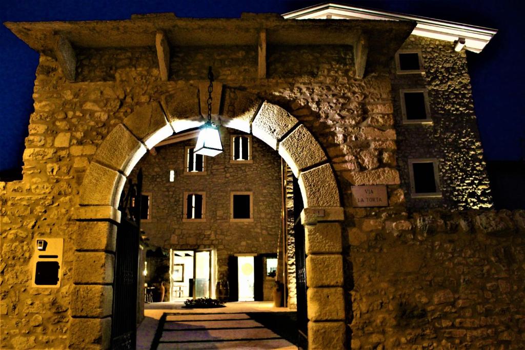 an entrance to a stone building at night at B&B Arco di Vino in Marano di Valpolicella