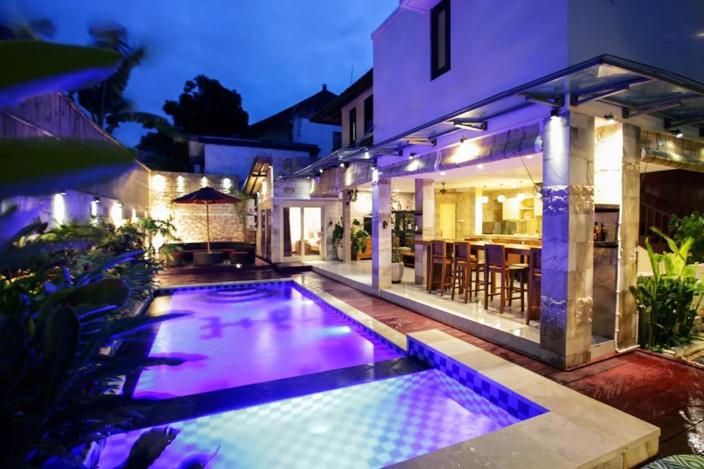 una piscina frente a una casa por la noche en Villa Margaux, en Seminyak