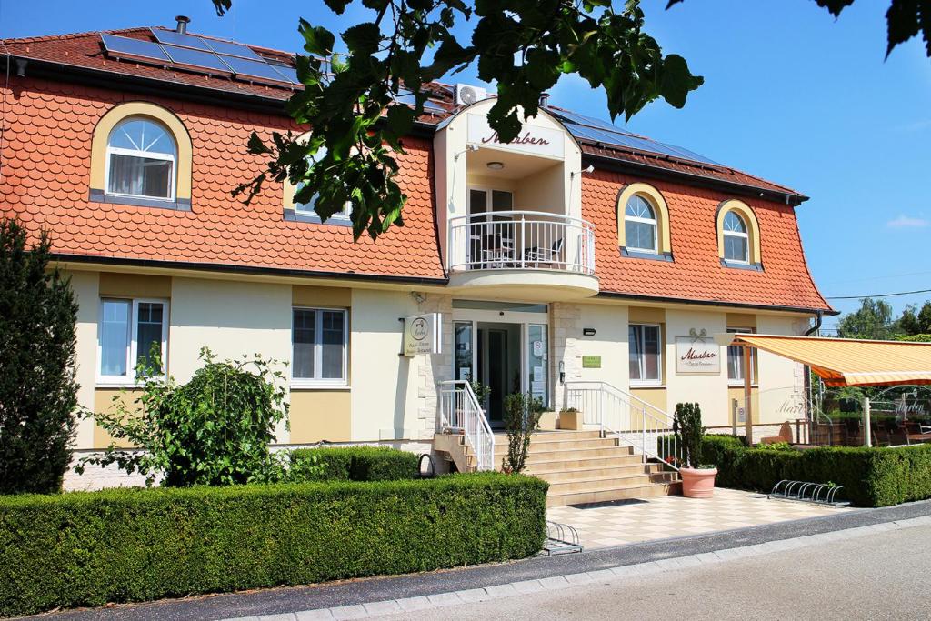 duży dom z pomarańczowym dachem w obiekcie Marben Panzió w mieście Hegykő