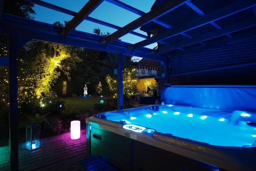 una bañera de hidromasaje en un patio trasero por la noche con luces en Thailand Lounge Whirlpool Sauna SPA en Geesthacht