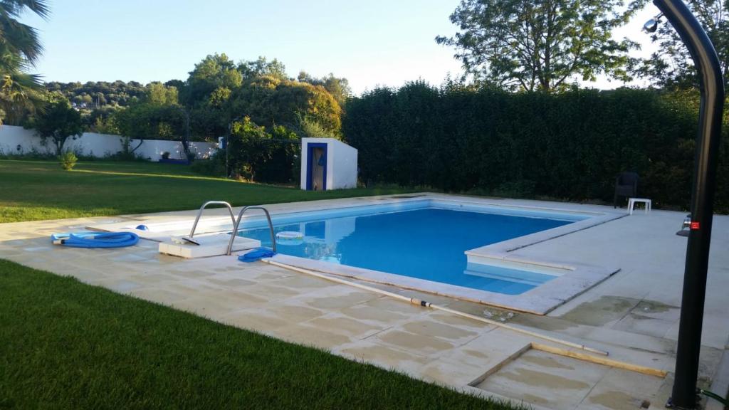 a swimming pool in a yard next to a field at Quinta da Nora Velha in Mato de Miranda