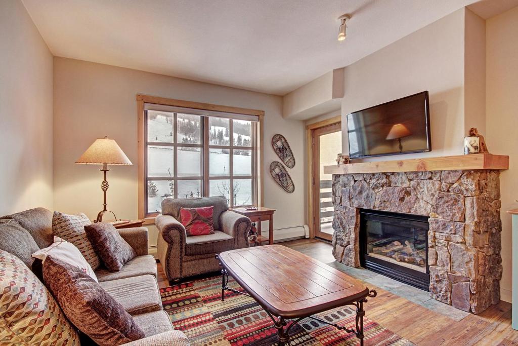 a living room with a fireplace and a tv at PP301 Passage Point in Copper Mountain