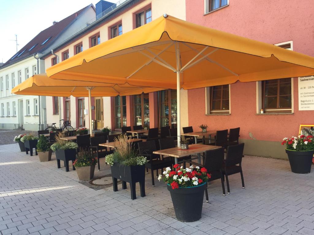 a restaurant with tables and chairs under an umbrella at Hotel Stadt Magdeburg in Perleberg