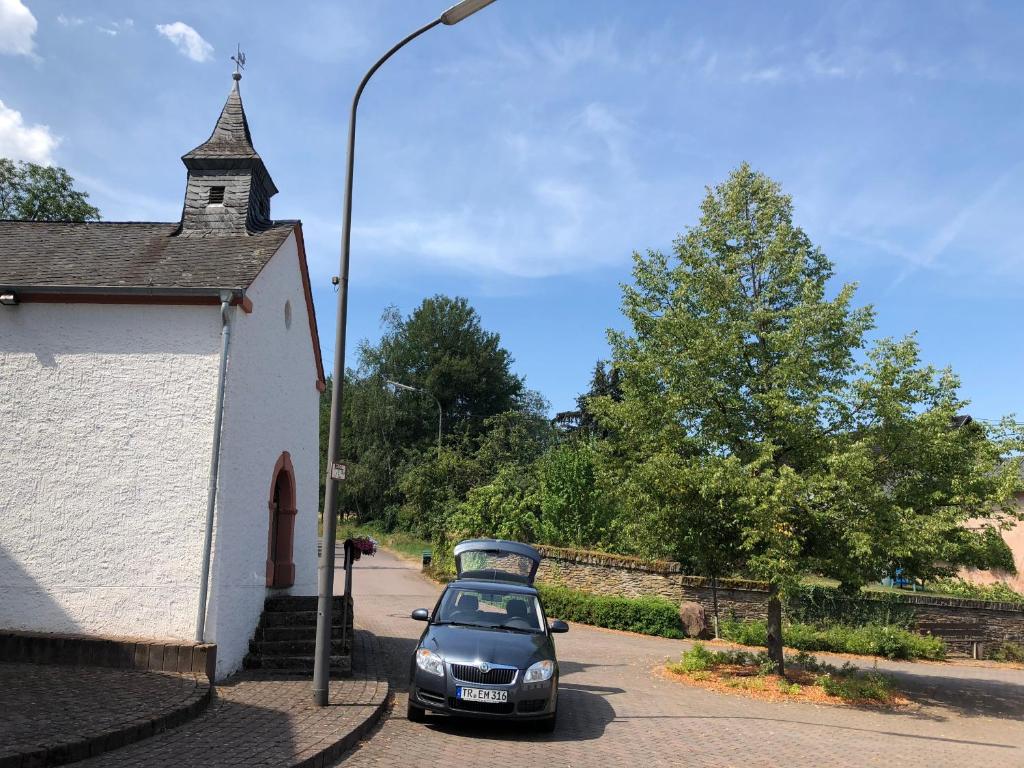 ein Käfer neben einer Kirche mit Straßenlicht in der Unterkunft Maat's Scheuer in Taben-Rodt