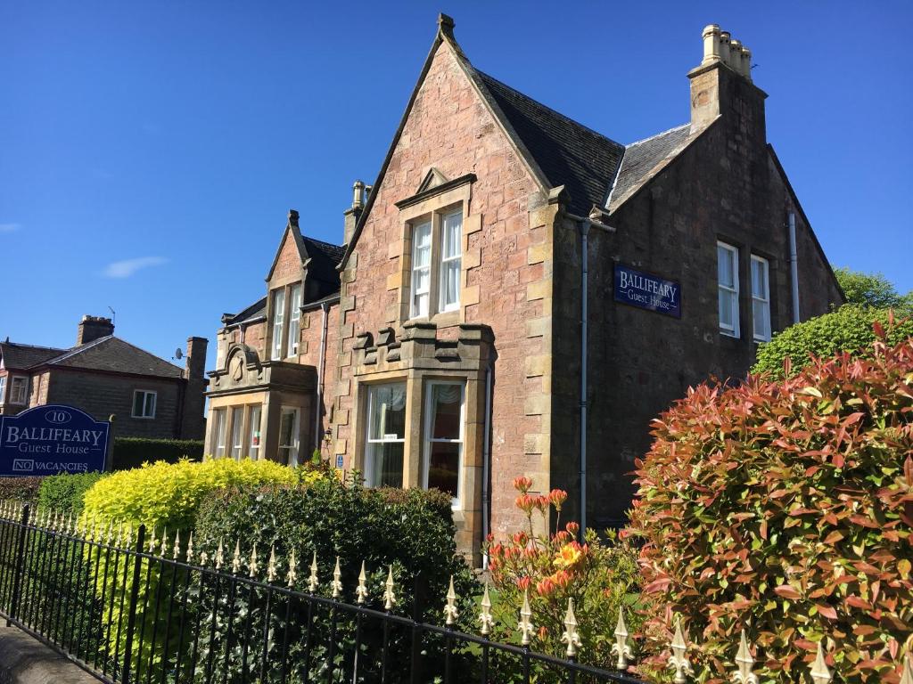 an old brick house with a fence in front of it at Ballifeary House in Inverness