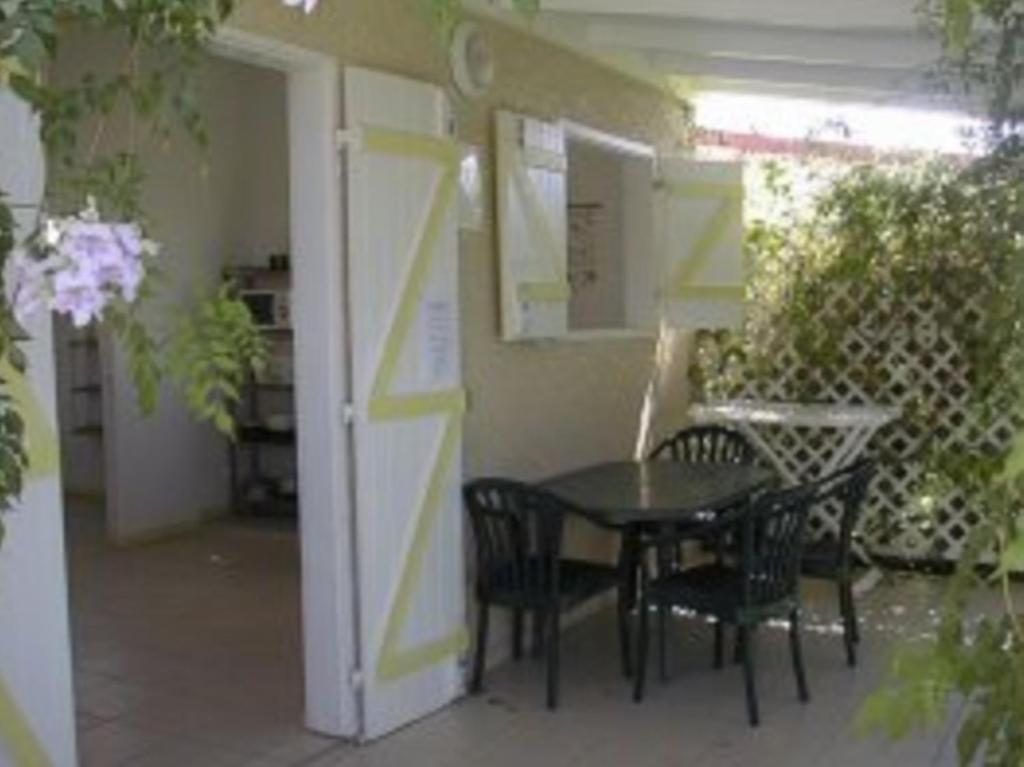 a patio with a table and chairs in a building at La Kallina in Grand-Bourg