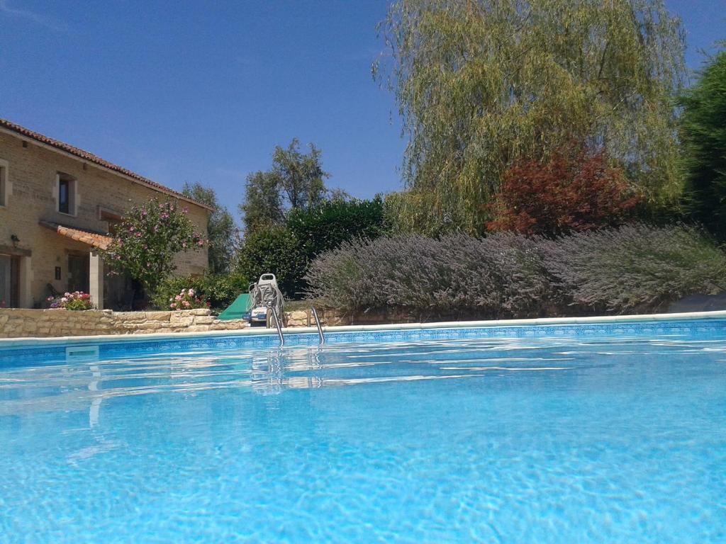 una gran piscina azul frente a una casa en Chez Valade, en Payroux