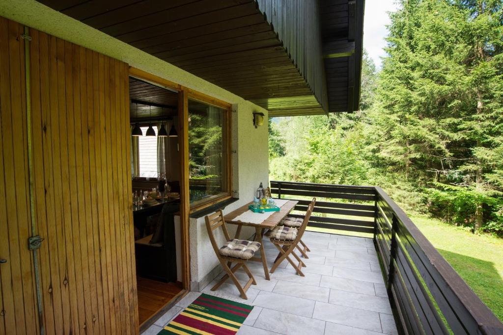 a patio with a table and chairs on a deck at Chalet Via Mons in Mojstrana