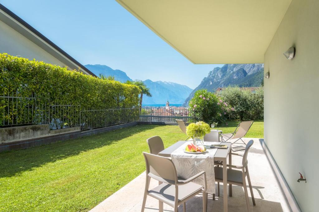 加爾達湖濱的住宿－La Busa Apartments - Garda Chill Out，天井上配有桌椅,享有草地美景