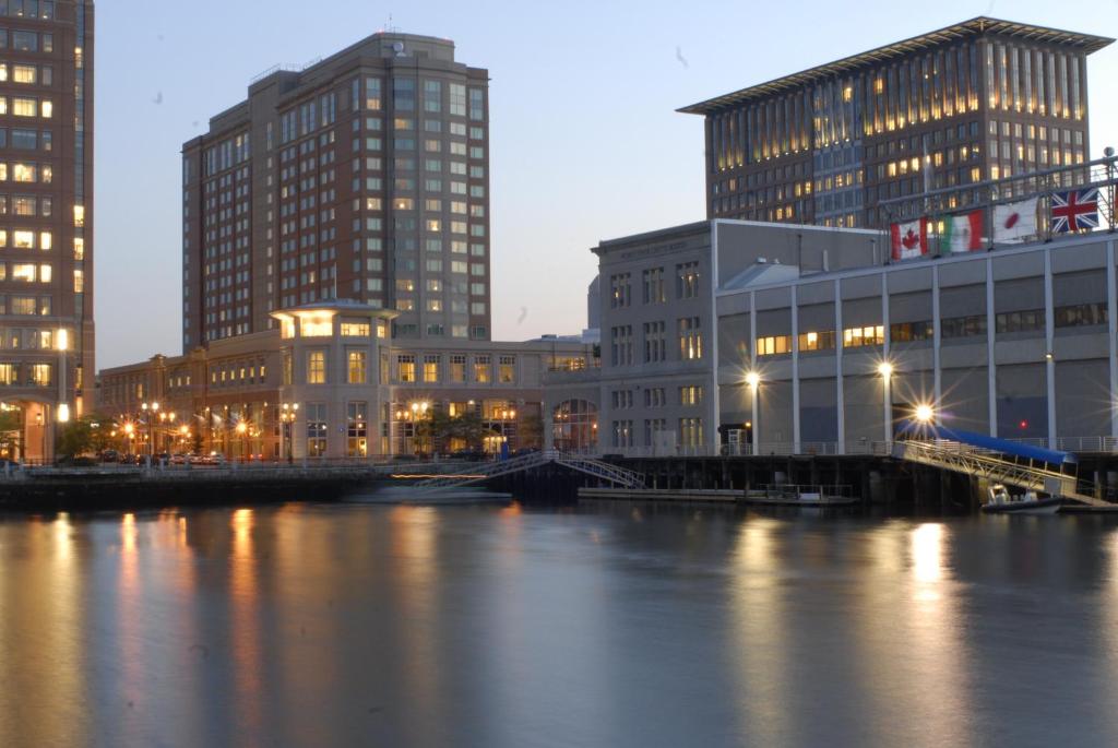 ボストンにあるSeaport Hotel® Bostonの高層ビル群と川の夜景