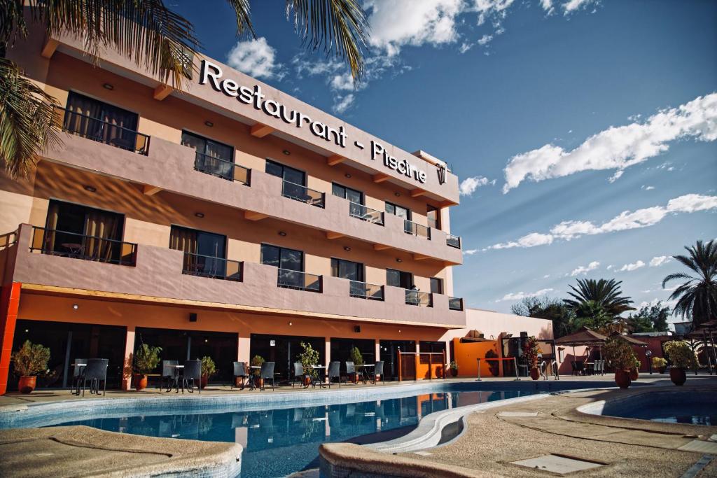 a hotel with a swimming pool in front of it at Hôtel IMAN in Nouakchott