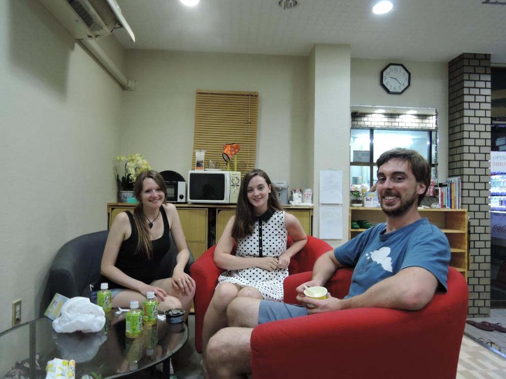 a group of people sitting in chairs in a room at Hotel Lucky in Osaka