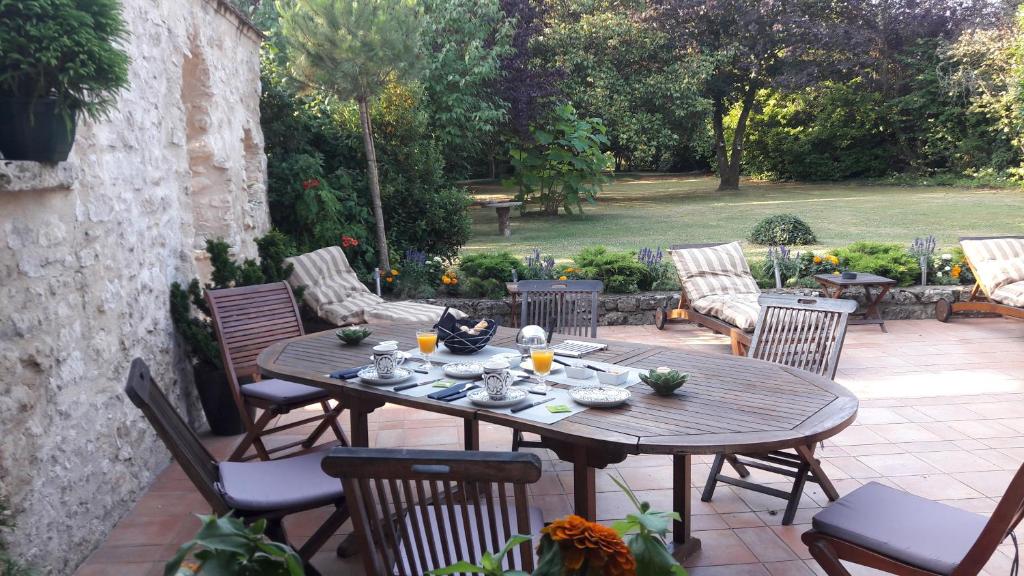 a wooden table and chairs on a patio at Les Ecureuils in Bougligny