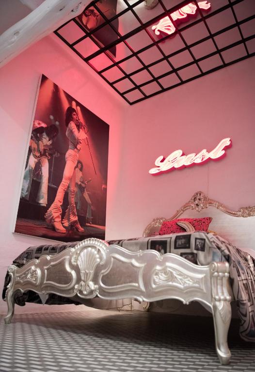 a bedroom with a silver bed and a poster on the wall at Pikes Ibiza in San Antonio