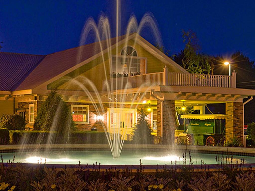 a house with a fountain in front of a house at Colonel Williams Resort and Suites in Lake George