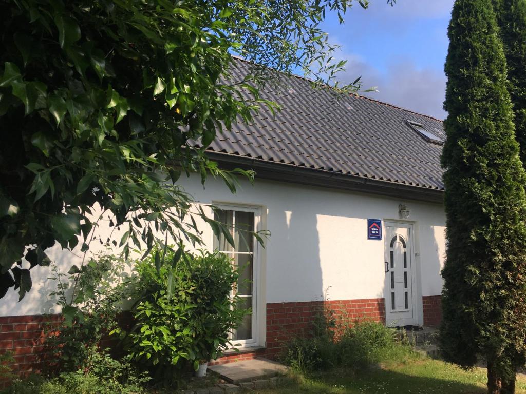 une maison blanche et rouge avec un toit noir dans l'établissement FeWo an der Warnow unweit der Ostsee, à Rostock