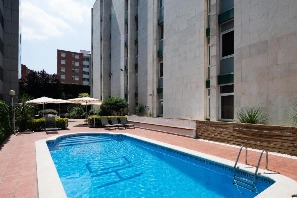 uma piscina ao lado de um edifício em Catalonia Bristol em Sant Andreu de la Barca