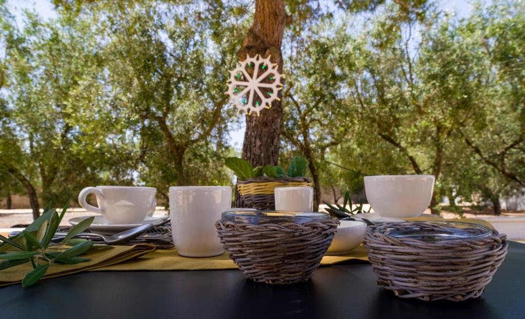 une table avec des assiettes et des tasses sur une table avec des arbres dans l'établissement I Ruscioli, à Torre Chianca