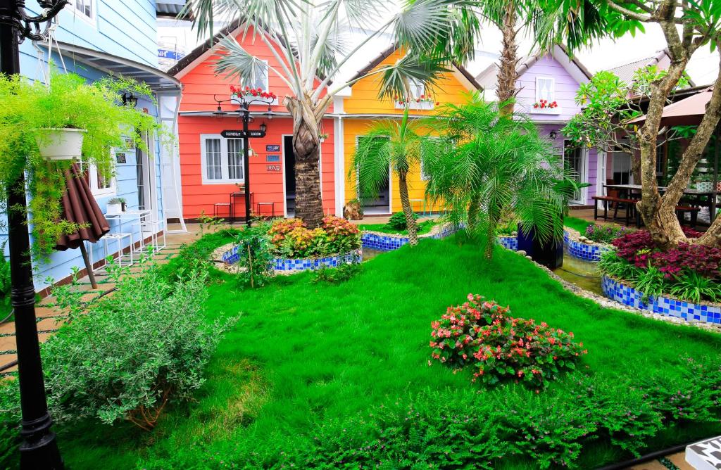 a yard with a green lawn in front of a house at Zan HomeStay in Buon Ma Thuot