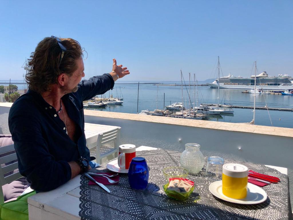 una mujer sentada en una mesa con vistas a un puerto deportivo en Marina Di Castello, en Cagliari