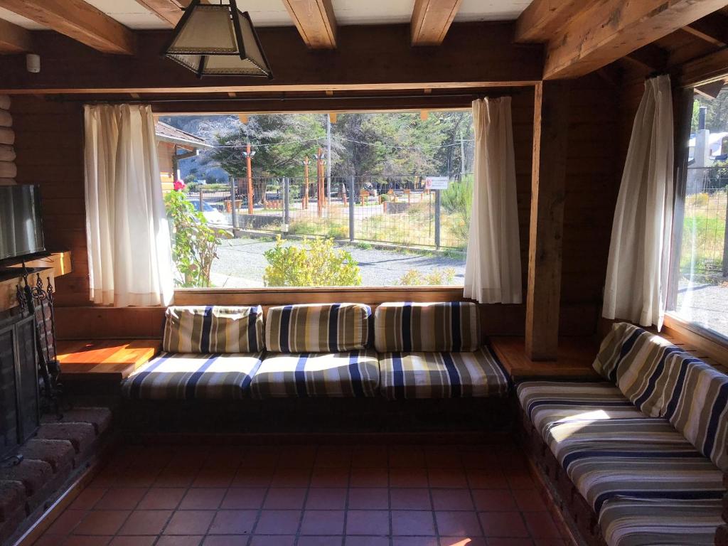 Habitación con sofás en una habitación con ventana en Cabaña frente al lago en San Martín de los Andes