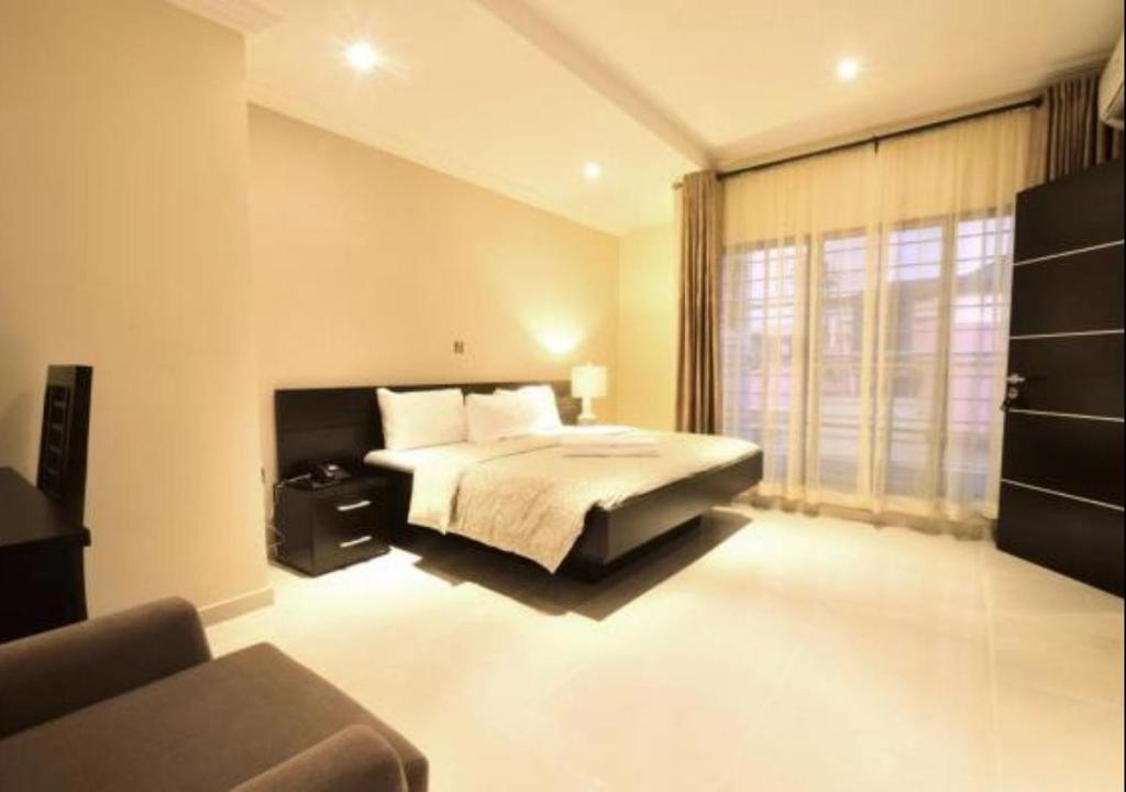 a bedroom with a bed and a large window at Villa Thirty Three in Lagos